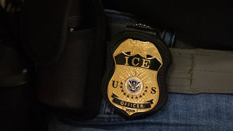 Un agente federal porta una insignia de ICE afuera del edificio de la corte federal en Nueva...