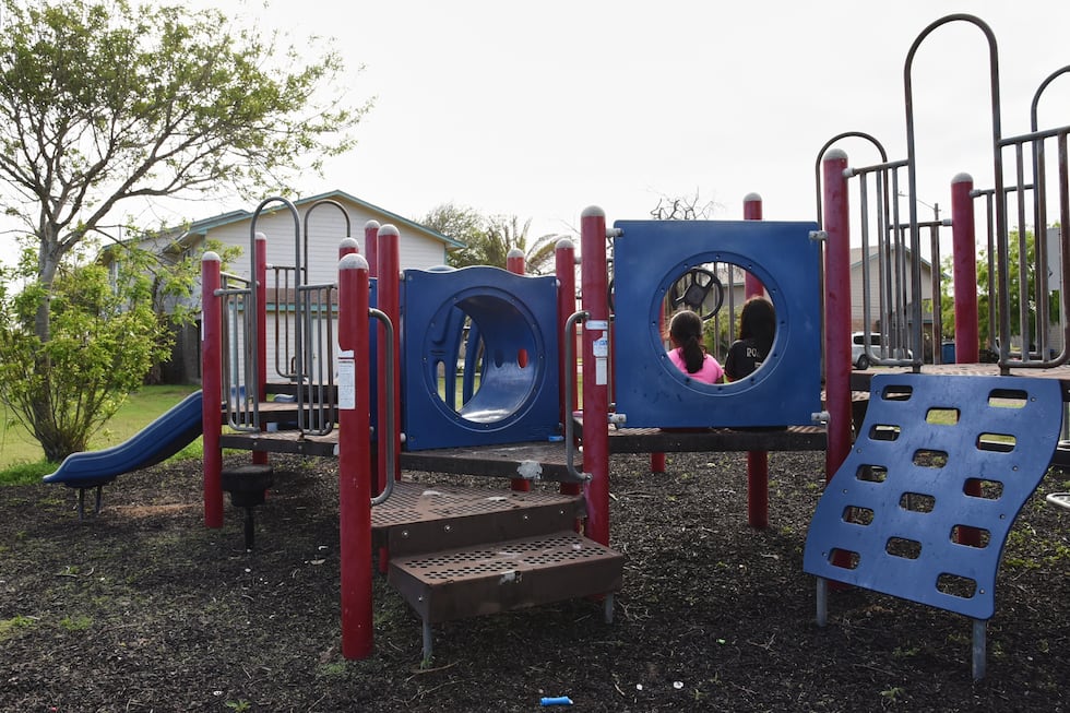 Dos hermanas juegan en un parque infantil del barrio, el cual permanece prácticamente vacío,...