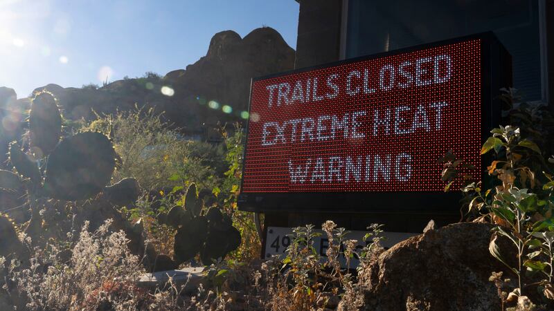 Un letrero avisa que un sendero para excursionistas está cerrado debido al exceso de calor, en...