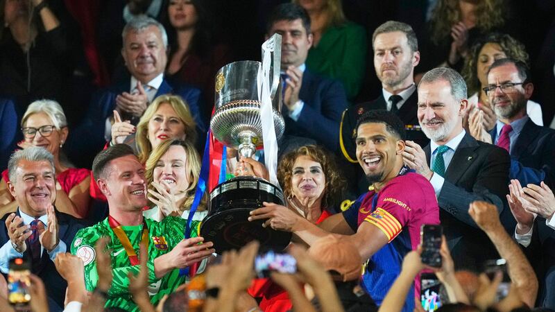 Ronald Araujo, del Barcelona, y el portero Marc-André ter Stegen levantan el trofeo después de...